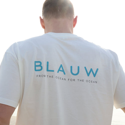 Person wearing a white t-shirt with 'BLAUW' branding on the back.