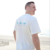 Person wearing a natural organic cotton T-shirt with blue text, standing outdoors.