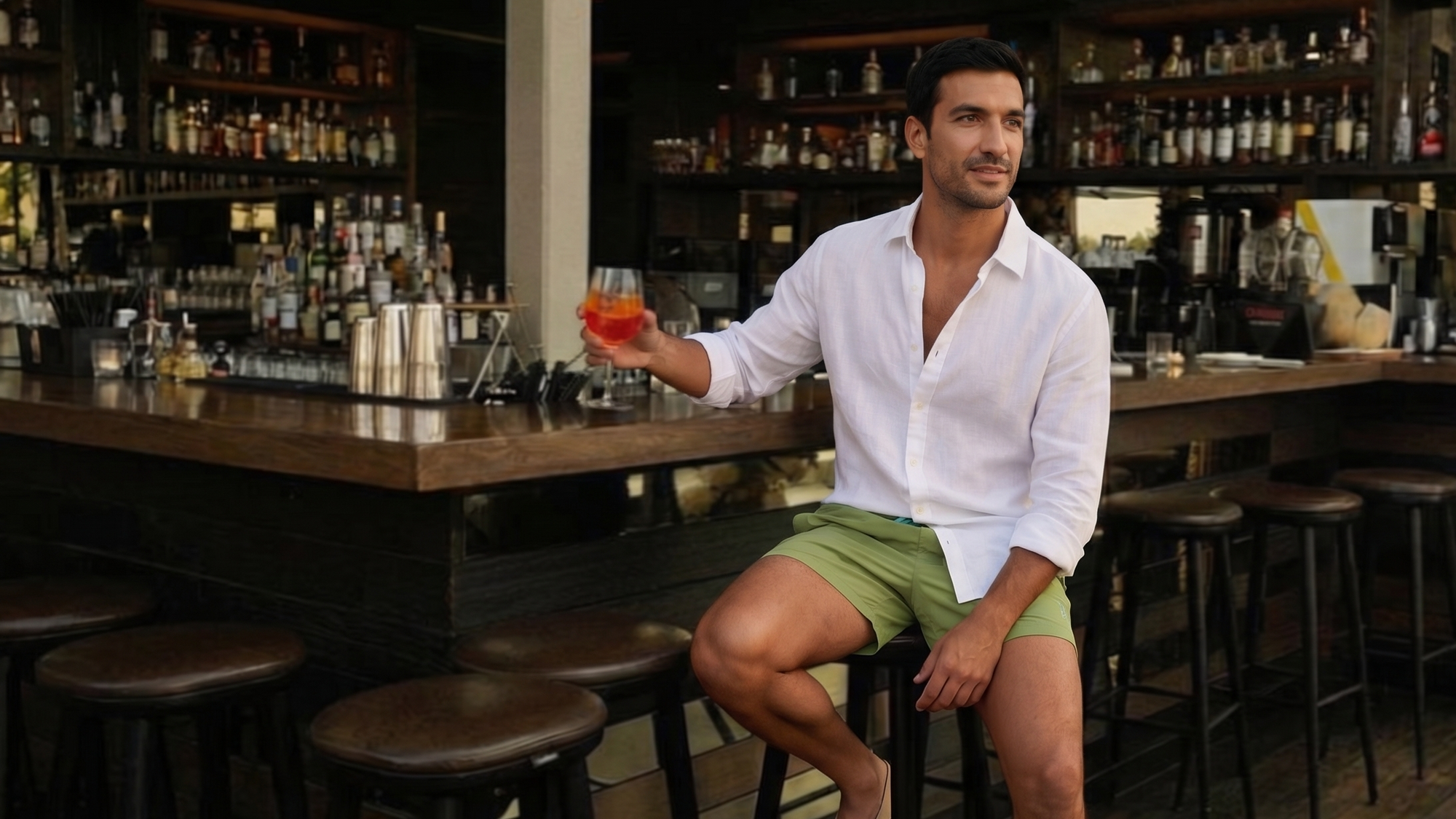 Man sitting at a bar in his stylish swim shorts.