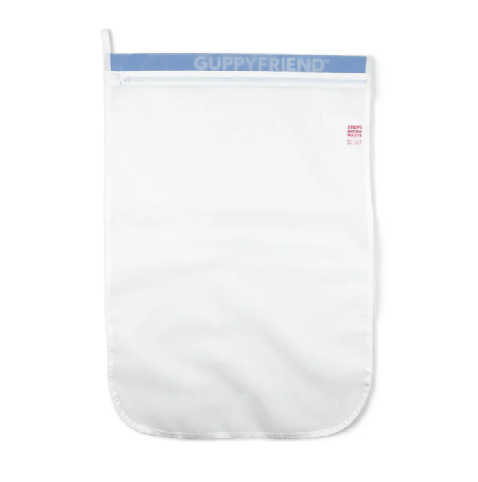 Flat lay of Guppyfriend microplastic filter bag; eco-conscious washing solution for recycled swimwear for men.
