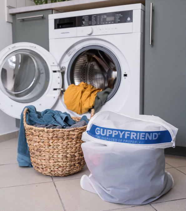 Guppyfriend microplastic washing bag next to Blauw recycled swim shorts; sustainable laundry solution for preserving sustainable swimwear.