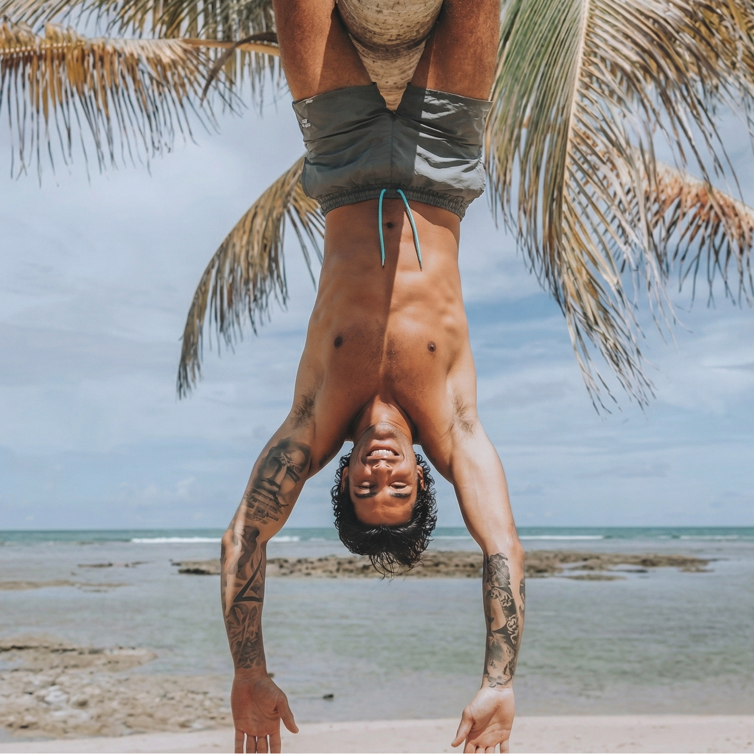 Person hanging upside down under a palm tree on a beach