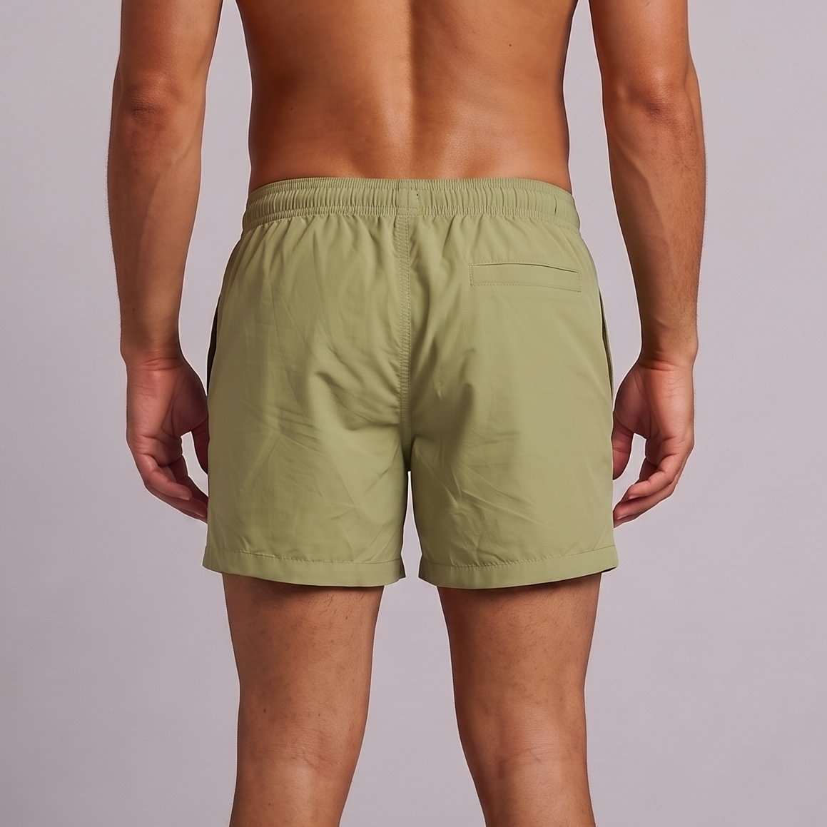 A man viewed from behind wearing quick drying Sage Green men’s swim trunks